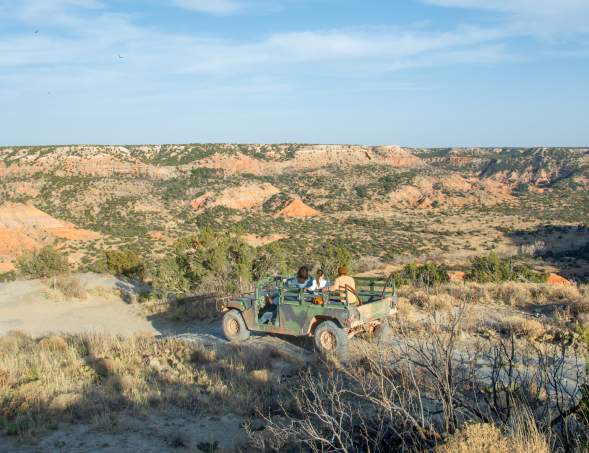 Group of friends in humvee overlooking palo duro canyon