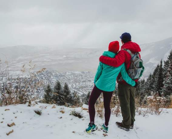 couple atop snowy mountain