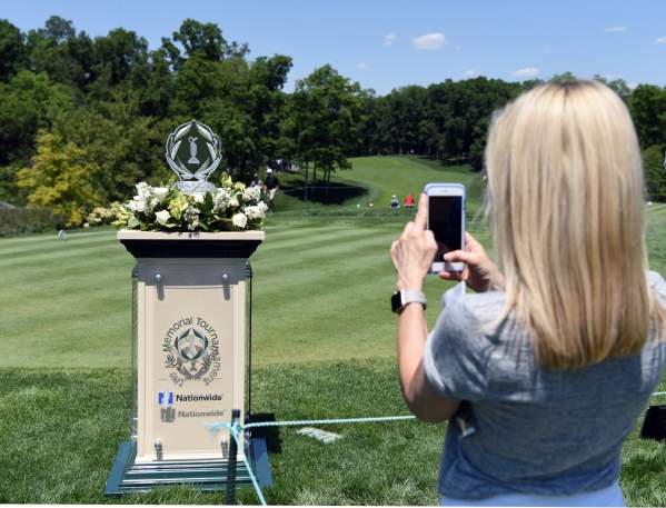 Girl taking a photo of the Memorial Tournament trophy while on course at Muirfield Village Golf Club
