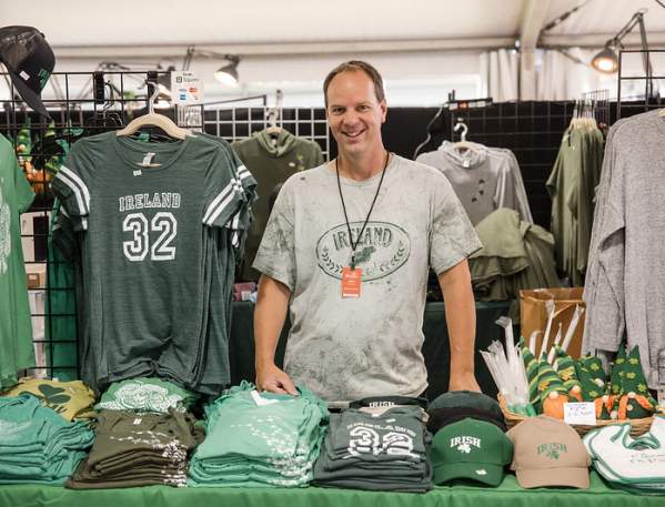 Man standing at his booth at the Dublin Irish Festival selling Ireland apparel