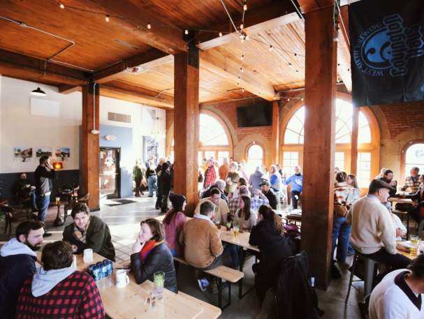 Groups of people enjoy the taproom at West Sixth Brewing Covington Haus.