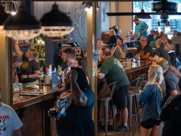A group of people enjoy the taproom at Wooden Cask