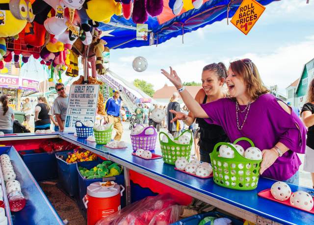 Two women play a game at the York State Fair.