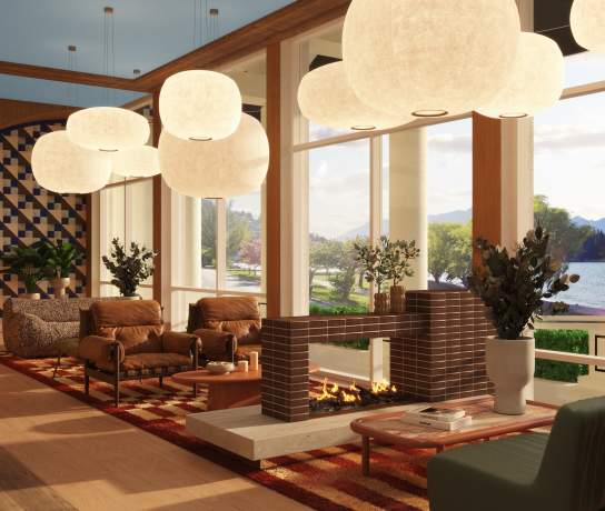 Render of the lobby of the renovated QT Hotel in Queenstown. Containing round white overhead feature lights, warm toned furniture and finishings, and a stone fireplace in the middle of the room.
