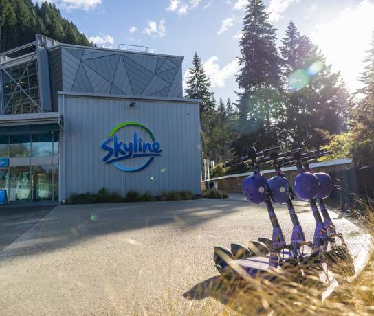 Beam electric scooters lined up out the front of the Skyline base building