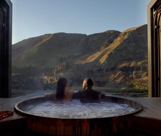 A couple look out at the beautiful vista at Onsen Hot Pools
