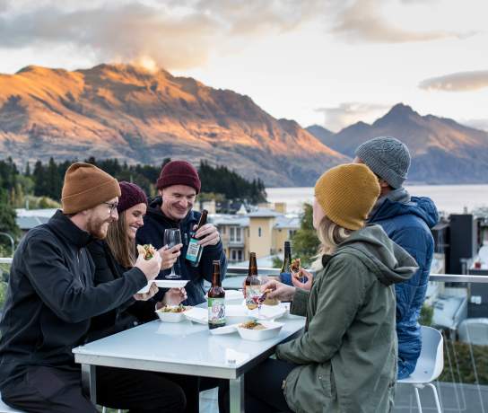 Friends enjoying cold beverages o the balcony at mi-pad
