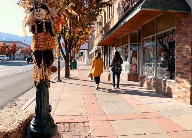 Two women walk down Main Street in Cedar City, Utah with shopping bags in hand