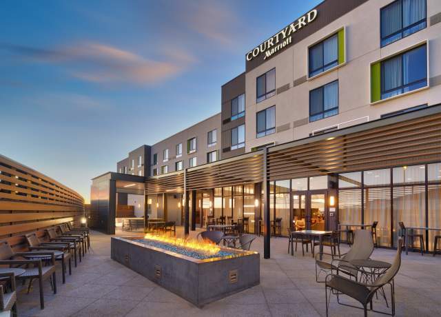 A group space on the patio at the Courtyard by Marriot in Cedar City with chairs and fireplace