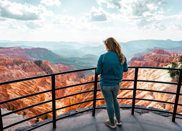 Woman in blue standing at the scenic Sunset Overlook at Cedar Breaks National Monument
