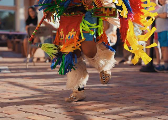 An indigenous Paiture dancer dances in vibrant regalia.