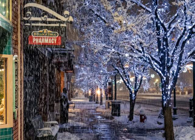 Snow and glowing blue holiday lights on Main Street in Cedar City