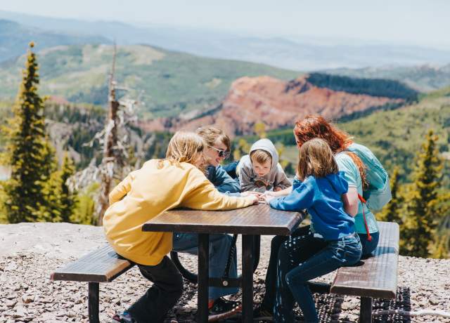 people sitting at picnic table outside  at brian head in the summer