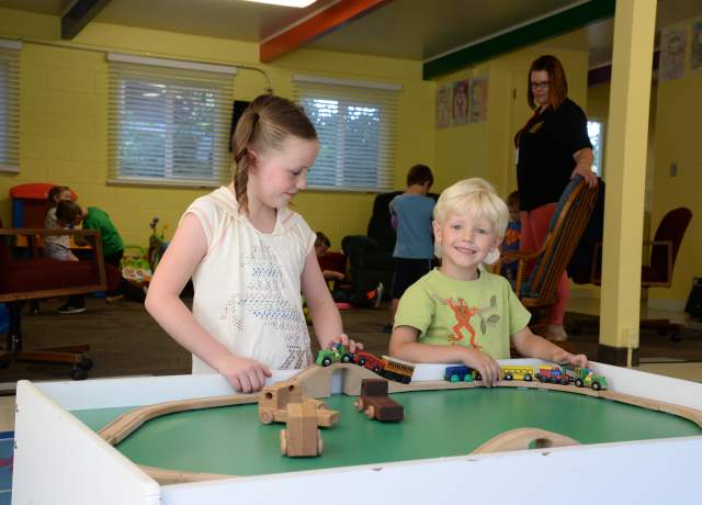 Children play with a wooden trail at the indoor play area at the Utah Shakespeare Festival Childcare facility.