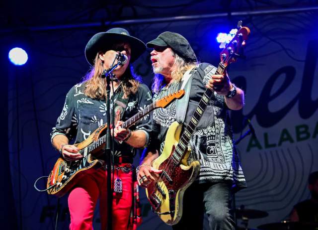 Musical artists sing and play guitar on stage at Old Town Live Music Festival.