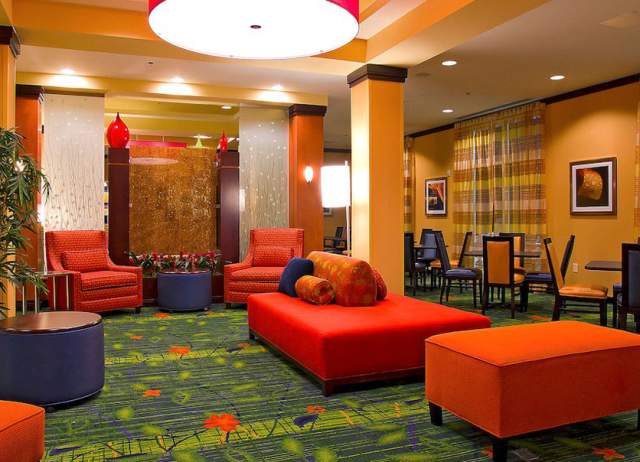 Hotel lobby with red and orange furniture and green carpet
