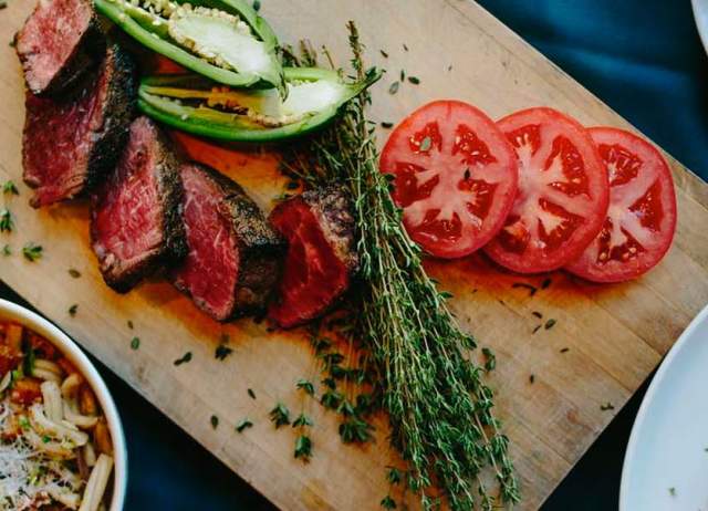 Overhead view of cutting board with steak and veggies