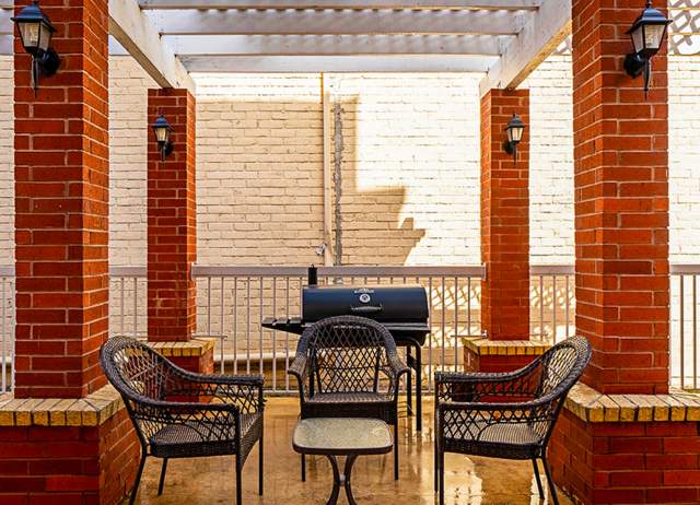 Outdoor patio with chairs and barbecue pit