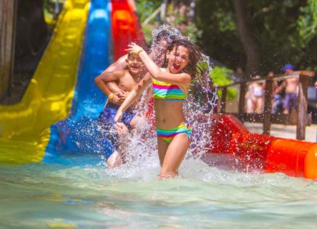 Girl walking away from waterslide splashing water