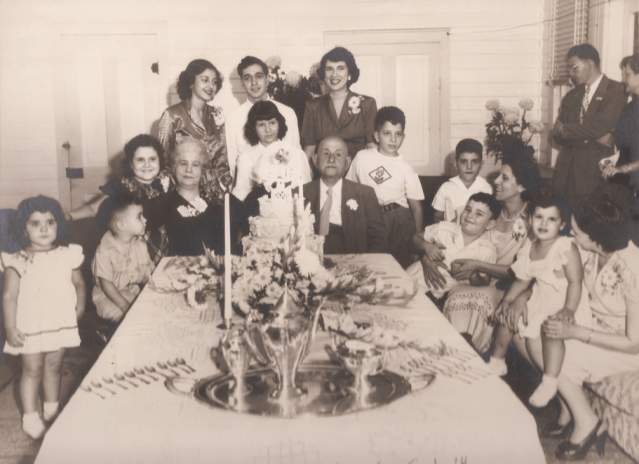 Mr. and Mrs. George Abdalla at a 1949 dinner celebrating their fiftieth wedding anniversary, surrounded by their grandchildren.