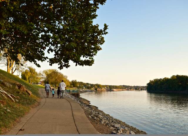 family walking along a riverwalk in the early fall