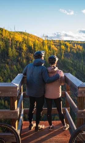 Couple taking in the view at Myra Canyon Trestles during Golden Larch Season 1