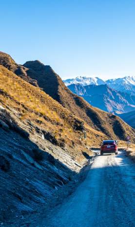 Tesla driving down Skippers Road with mountains in background
