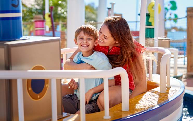 Mother and son on Grandad Dog's Boat Ride at Peppa Pig Theme Park in LEGOLAND Florida Resort.