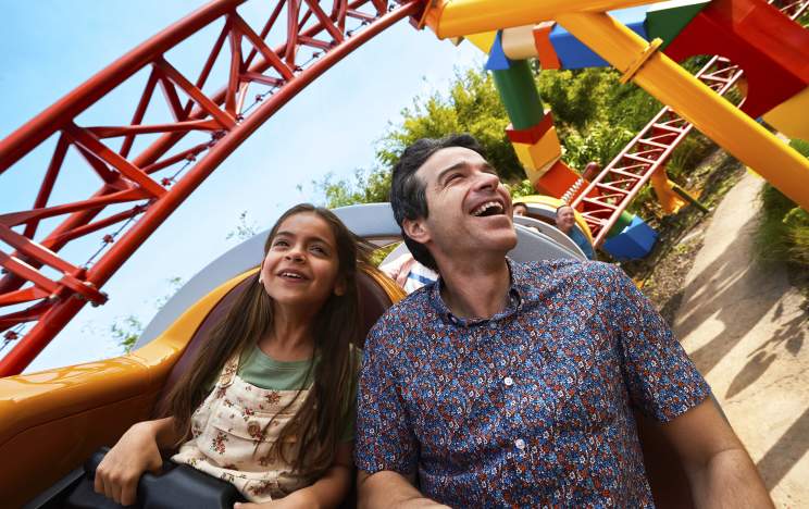 A father and daughter on the Slinky Dog Dash rollercoaster at Toy Story Land in the Magic Kingdom at Walt Disney World Resort