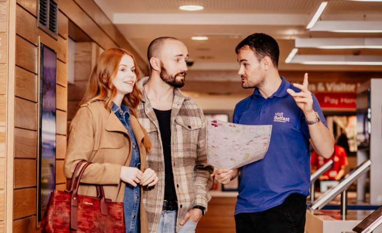 Staff helping a couple in the Visit Belfast Welcome Centre.