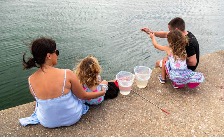 A family with a crab line on the water front