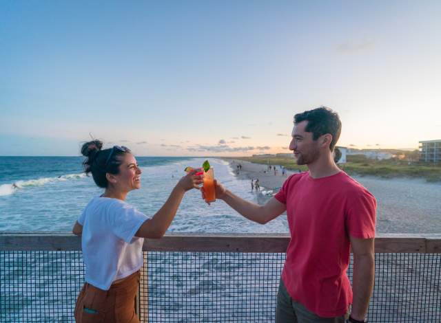 Couple clinking their drinks together on the Crystal Pier