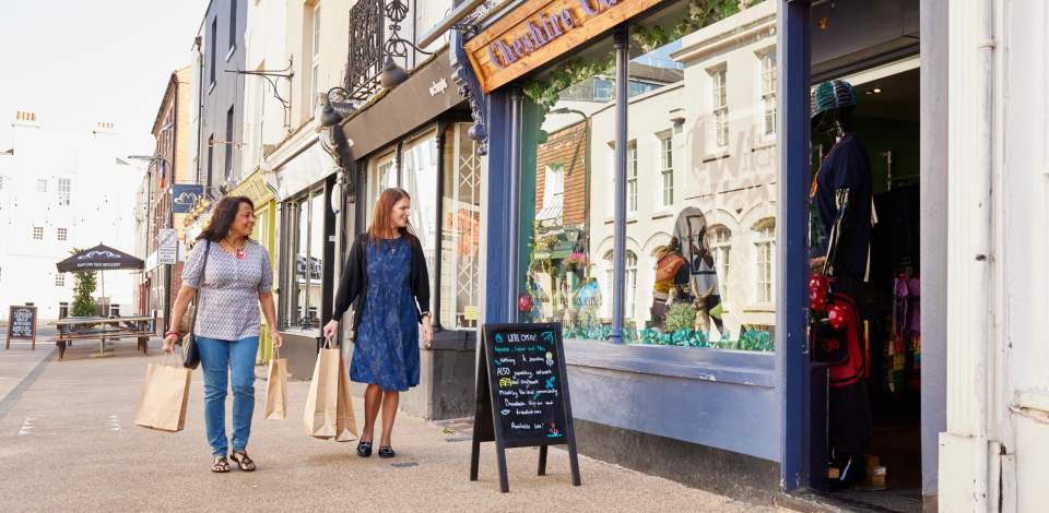 Two people walking past a shop in the pedestrain area of Carlton Place