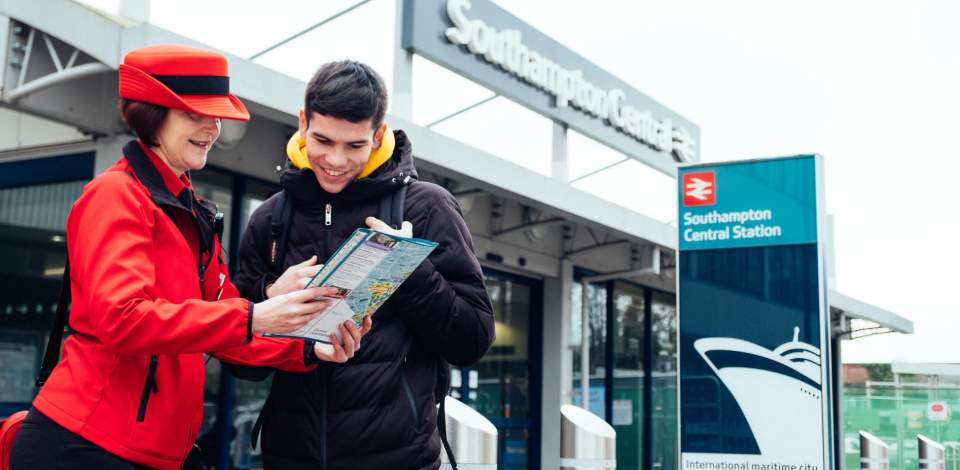 Two people looking down at a map outside Southampton Central Train Station