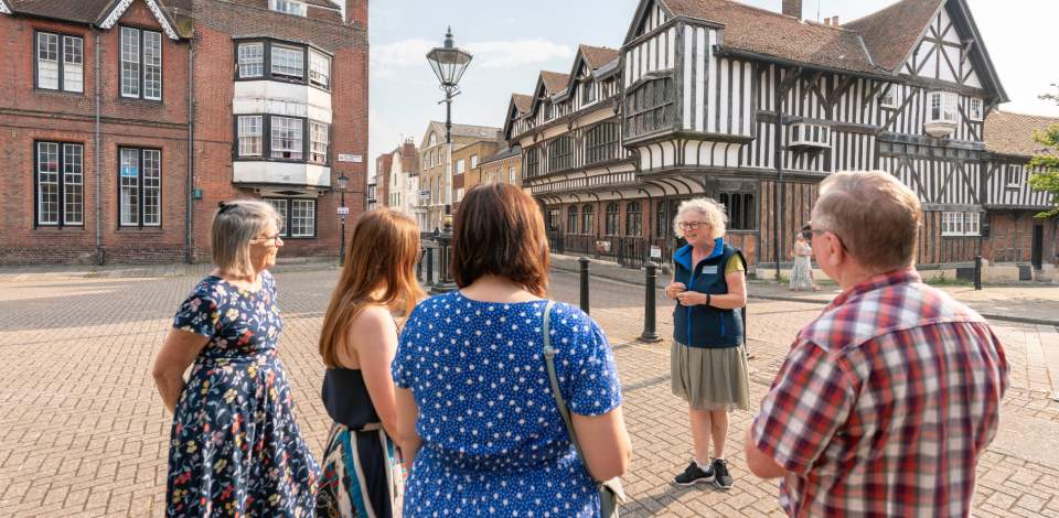 STGA Tour Guide with group outside Tudor House