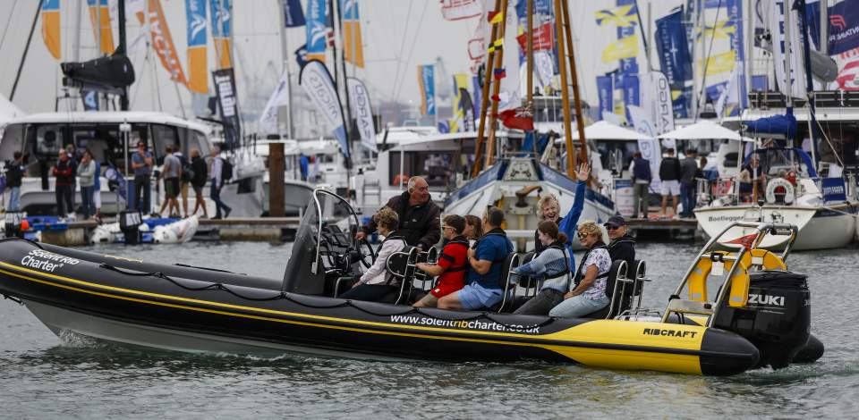 Family in speedboat driving on water at Southampton International Boat Show
