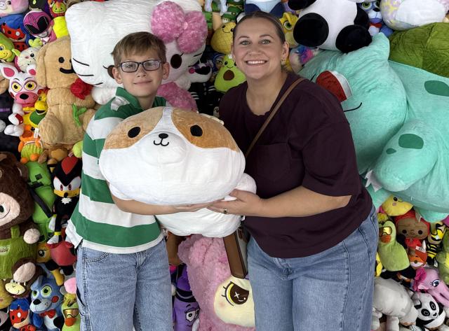 Mother and Son with upgraded prize at the prize wall