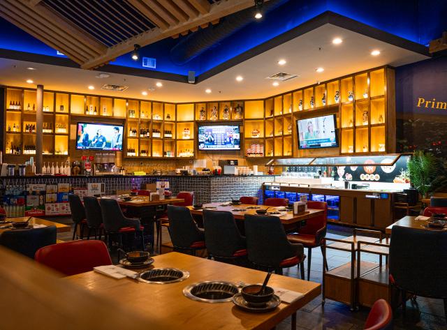 Dining Table with Hot Pots and Bar in the Background with wall of alcohol bottles