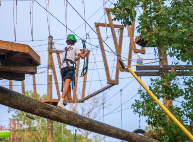 Young Man crossing pole on TreeVentures course.