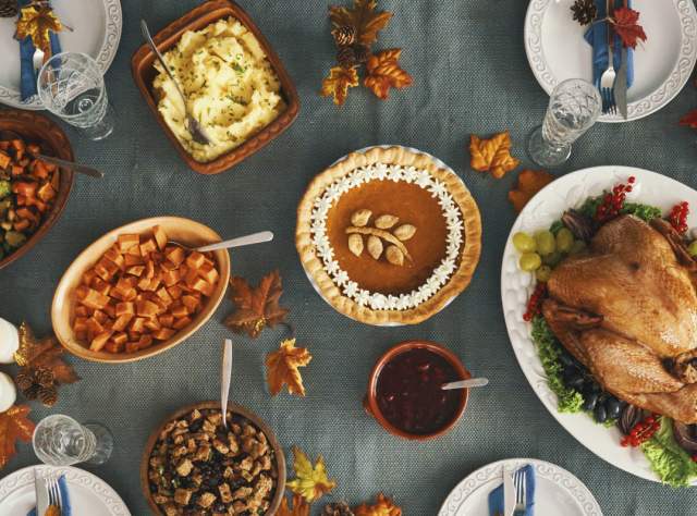 A table filled with Thanksgiving dishes like turkey and vegetables