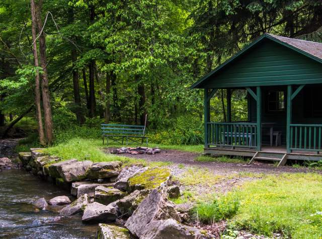 A photo of the exterior of a green cabin at Allegheny State Park