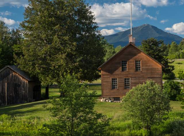 The green landscape and exterior of the John Brown Farm State Historic Site