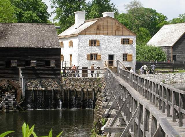 The exterior of Phillipsburg Manor Mill and Bridge from across a bridge
