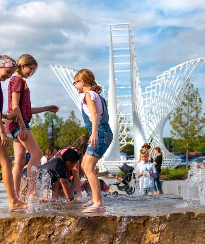 kids playing in the kids canal water feature at promenade park in fort wayne