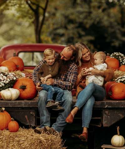 Family with pumpkins in antique red truck in Festival Country