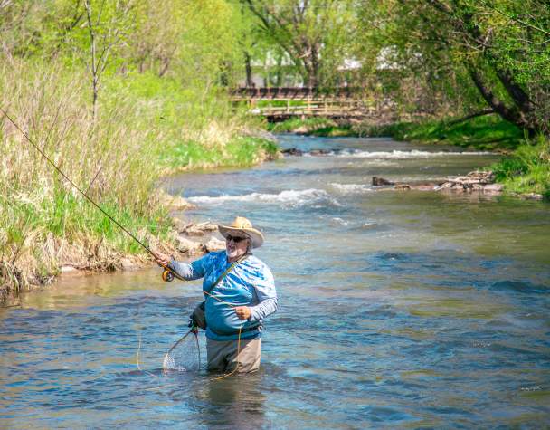man fly fishing in the waters of rapid creek found in rapid city, sd
