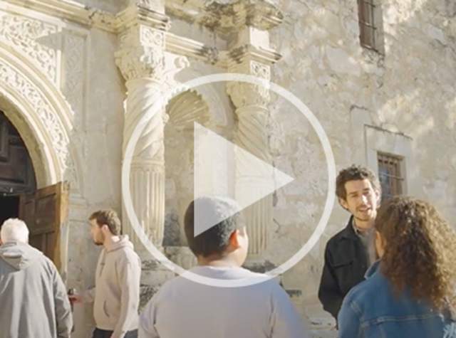 Tour guide talking to children in front of Alamo