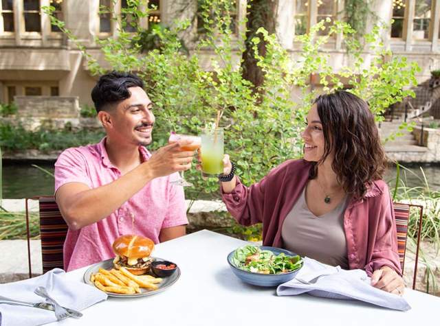 Man and woman toasting on the San Antonio River Walk.