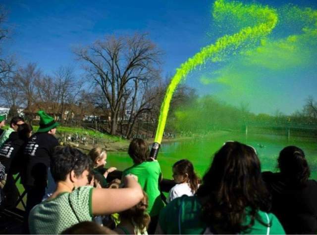 Group putting green liquid in river for the Fort Wayne Firefighters Get Green Fest 2026