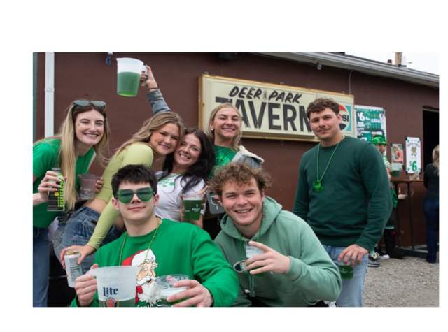 Patrons pose in front of Deer Park Irish Pub during St. Patrick's Day celebration.